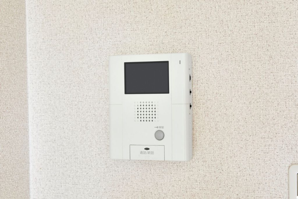 A white wall-mounted phone positioned beside a door, providing easy access for communication.